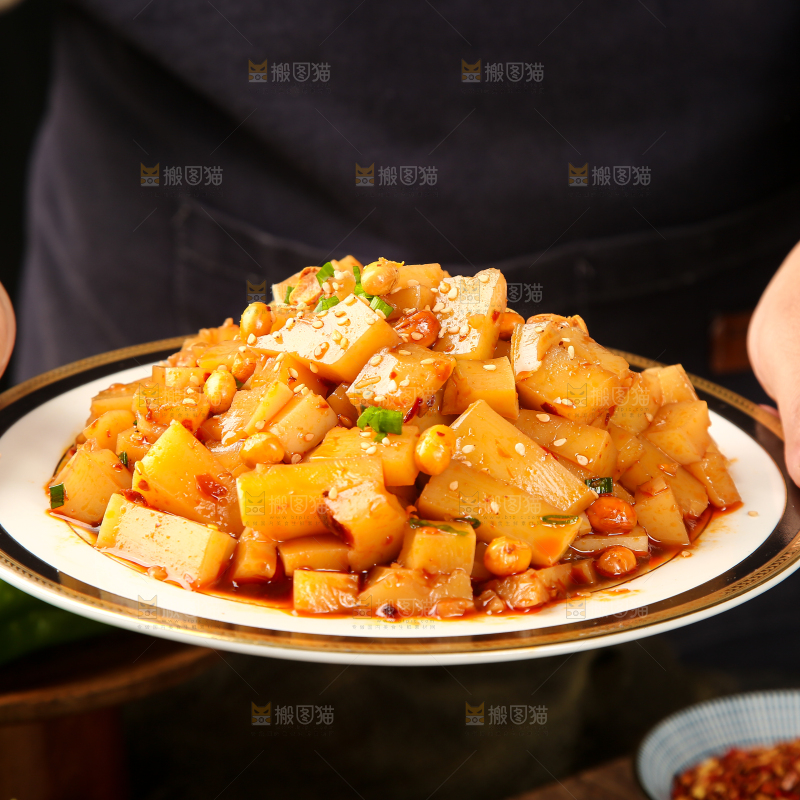 手里端着一盘香辣米豆腐