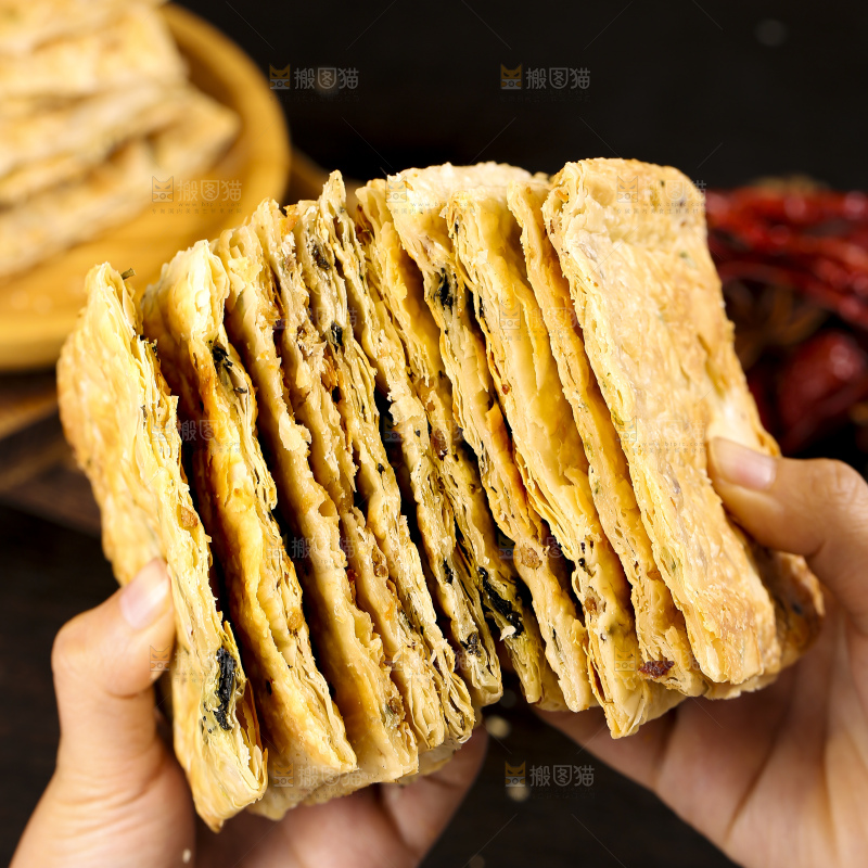 手里拿着梅干菜锅盔