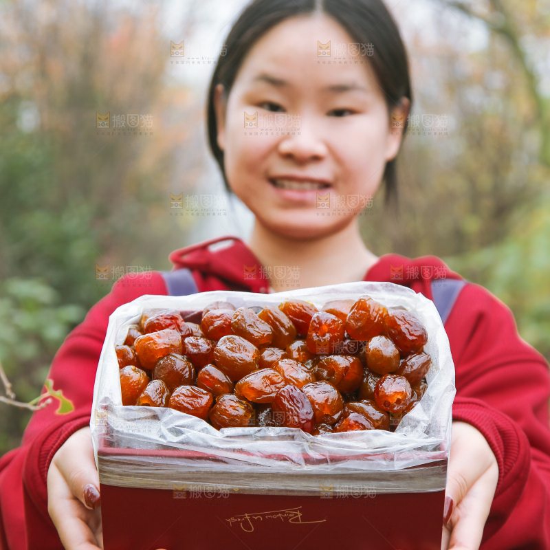 手里拿着一盒蜜枣