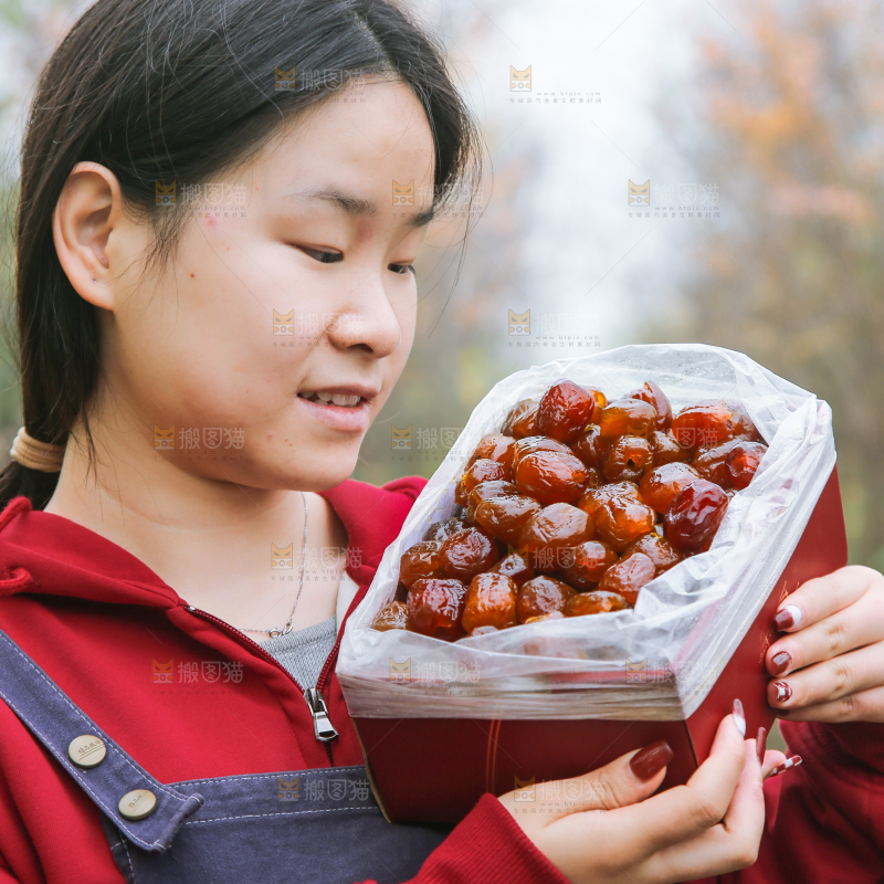 手里拿着一盒蜜枣