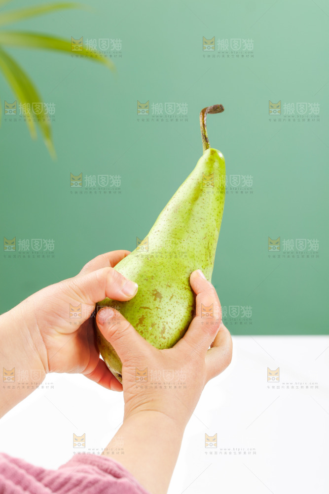 手里拿着青啤梨