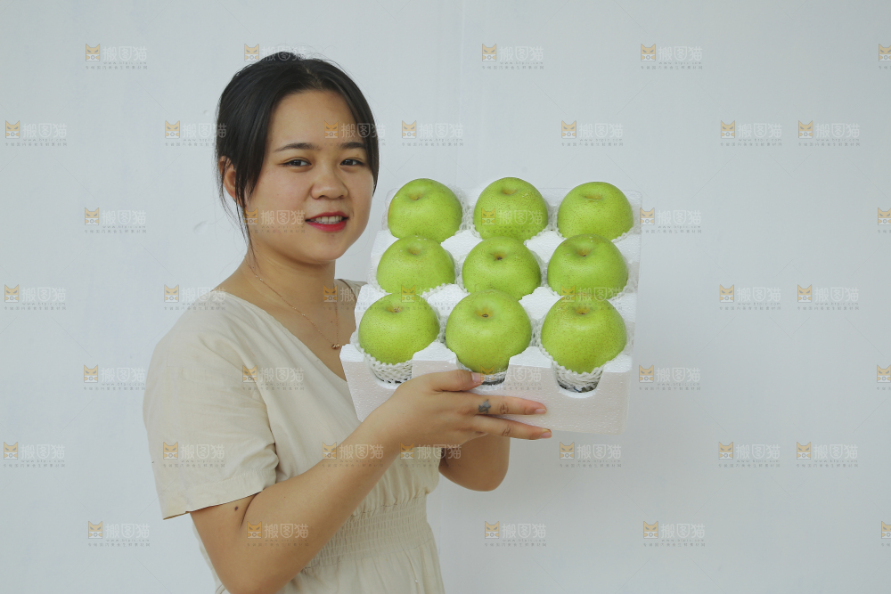 手里拿着一盒青皇冠梨